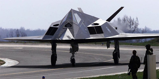 Hai binh sĩ Mỹ đứng cạnh một máy bay tàng hình F-117 tại căn cứ không quân Spangdahlem
